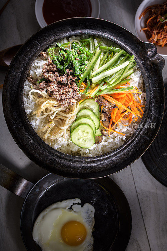 BI Bim Bap，拌菜饭，顶视图与热酱在铸铁锅